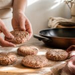 A plate of golden-brown turkey sausage patties with fresh herbs.